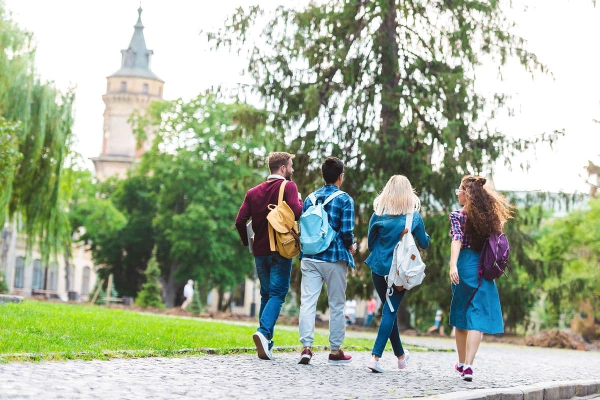 back view of students with backpacks walking on street_AdobeStock_217121862